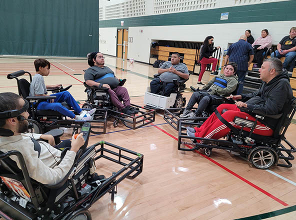 Individuals in power soccer chairs in circle.